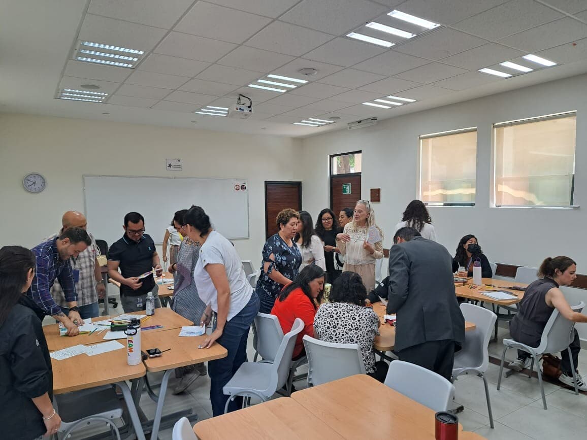 Docentes conversando de pie durante el cierre de un taller Mirari en el colegio.