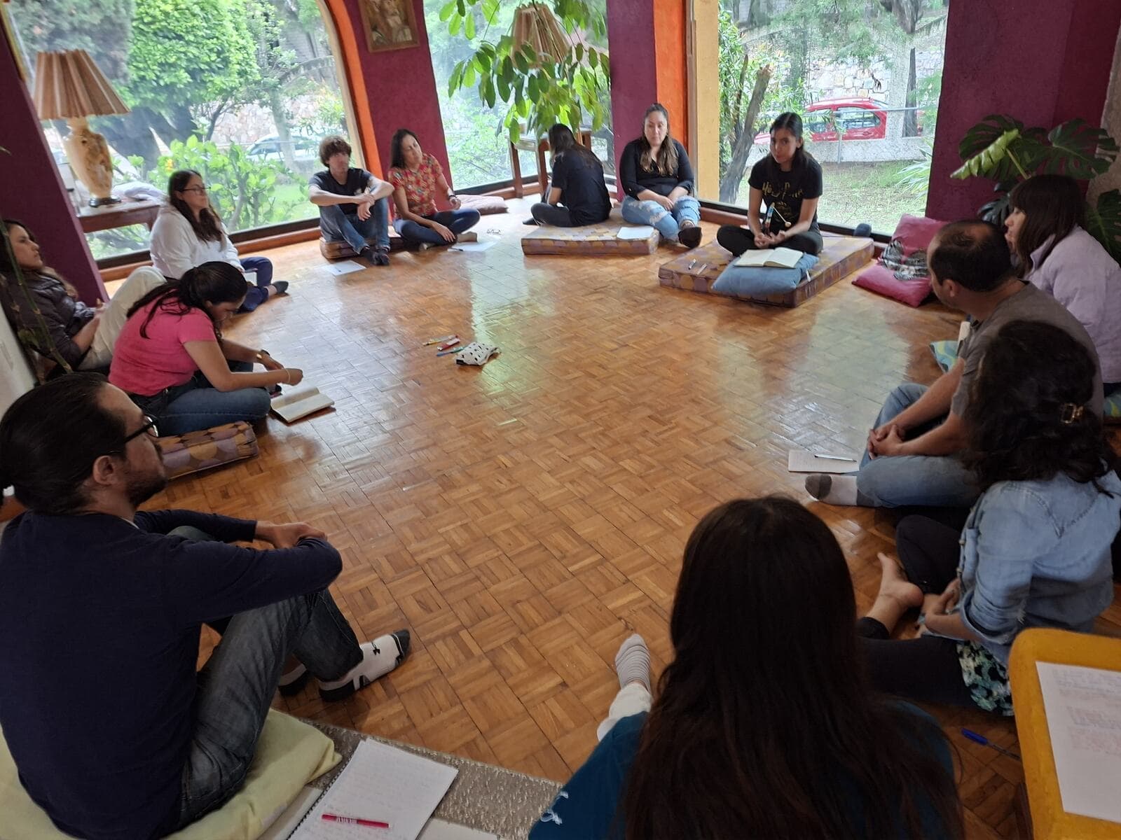 Grupo sentado en círculo pintando durante un taller Mirari.