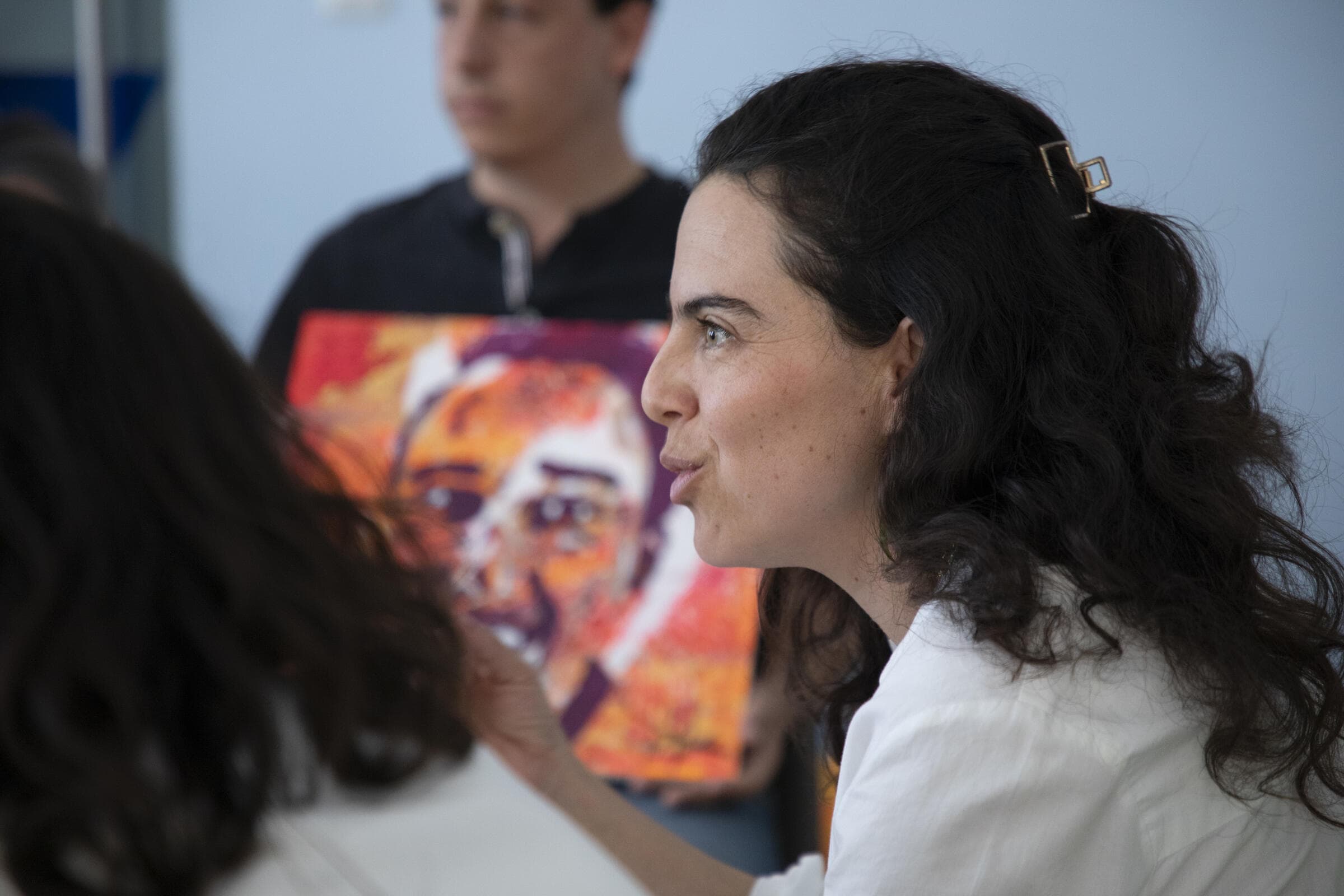 Facilitadora de Mirari junto a un retrato pintado a color